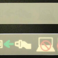 Example of a product made from backlit overlay label printing from Marking Systems showing a buckle-up symbol and turn off electronics sign for airplanes.
