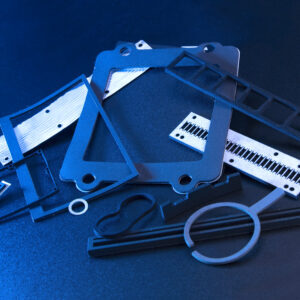 A variety of thin metal tools and equipment for die-cutting in an unorganized pile at Marking Systems.